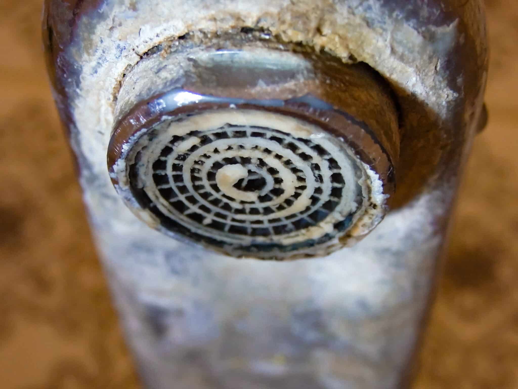 A faucet with hard water stains and limescale in the bathroom can cause low water pressure.
