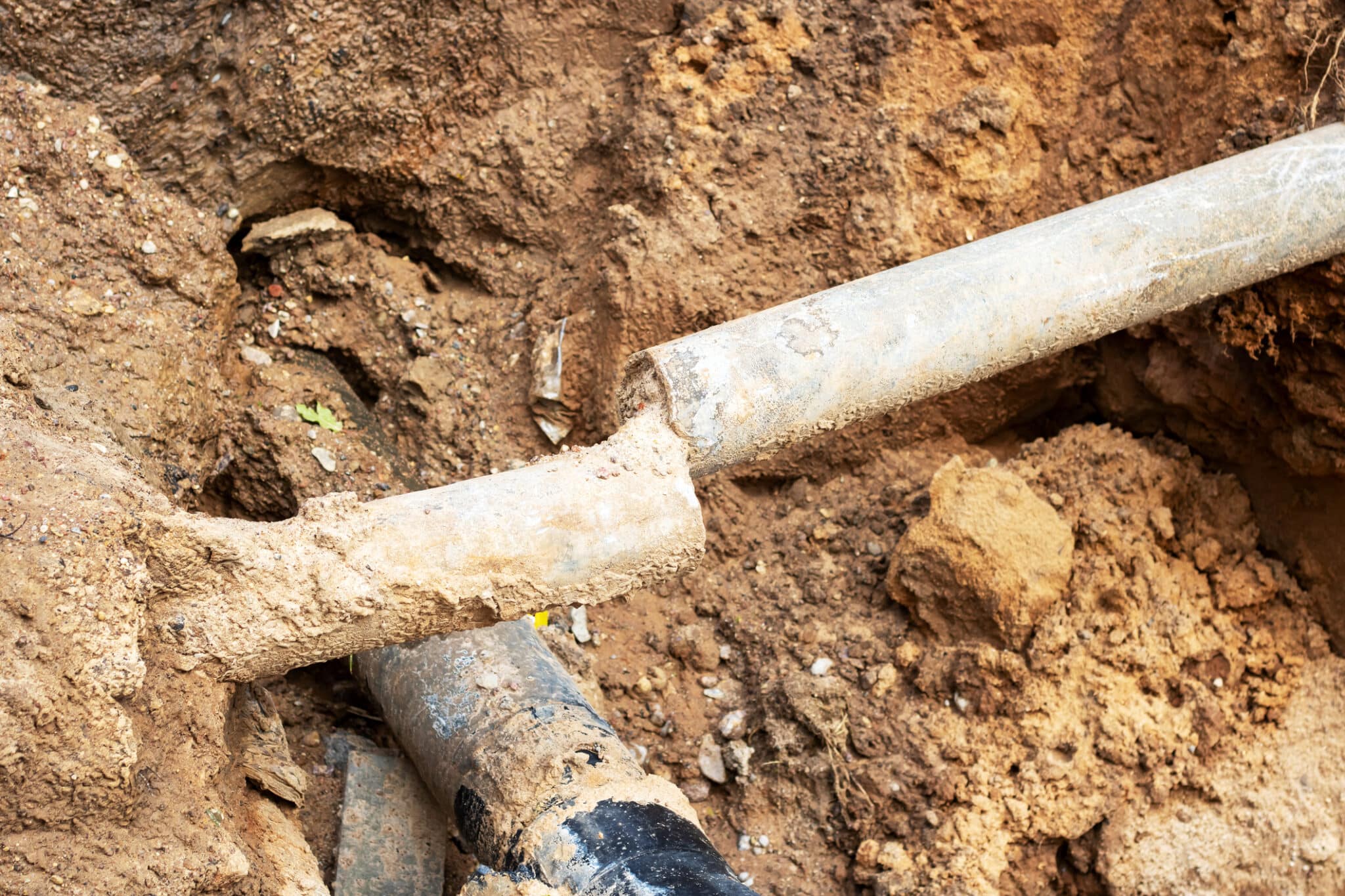 Soil chemistry and ground movement can stress buried pipes, requiring a new water service line.