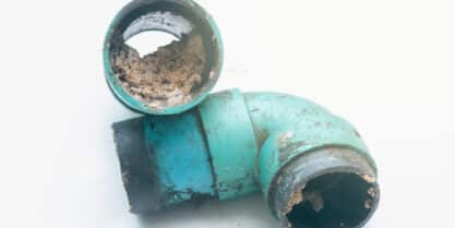 Pipe clogged with fats, oils, and grease, causing sewer blockage and warning signs of a broken sewer line.